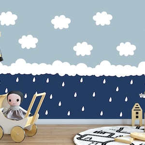 May include: A white doll in a gray dress sits in a white wooden doll stroller. The stroller has wooden wheels. The background is a blue wall with white clouds and raindrops.