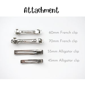 Peut inclure: Un ensemble de quatre pinces &agrave; cheveux en m&eacute;tal argent&eacute; &eacute;tiquet&eacute;es Attachment. Les articles incluent une pince automatique de 60 mm, une pince automatique de 70 mm, une pince crocodile de 55 mm et une pince crocodile de 45 mm, dispos&eacute;es horizontalement.