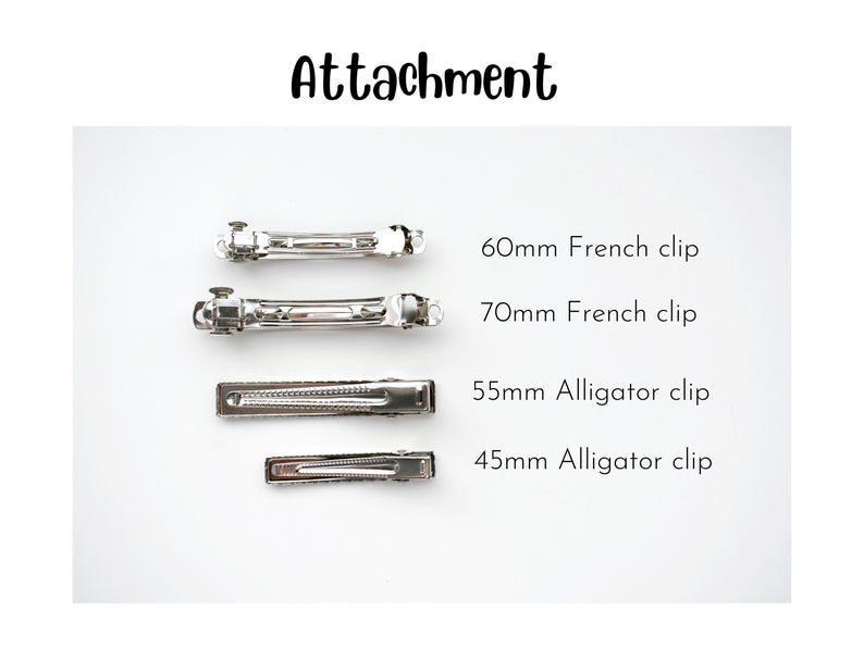 Peut inclure: Un ensemble de quatre pinces &agrave; cheveux en m&eacute;tal argent&eacute; &eacute;tiquet&eacute;es Attachment. Les articles incluent une pince automatique de 60 mm, une pince automatique de 70 mm, une pince crocodile de 55 mm et une pince crocodile de 45 mm, dispos&eacute;es horizontalement.
