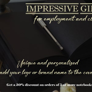 May include: A black leather bound notebook with a silver pen lying on top. The notebook is on a dark wooden surface with white flowers and a gold pen. The text on the image reads "IMPRESSIVE GIFTS for employment and clients Unique and personalized (add your logo or brand name to the cover) Get a 30% discount on orders of 5 or more notebooks".