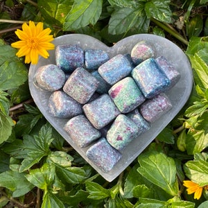 May include: A heart-shaped dish filled with tumbled green, blue, and red ruby zoisite stones. The stones are smooth and polished, and they have a variety of shapes and sizes.