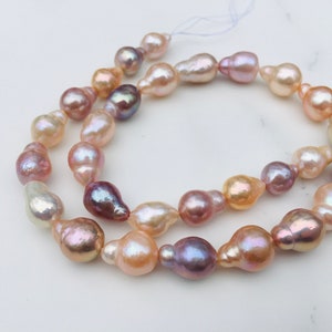 Puede incluir: Una hebra de perlas barrocas en tonos rosa, melocotón y lavanda. Las perlas son de forma irregular y tienen un alto brillo.