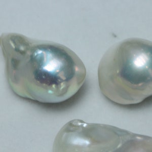 May include: Four iridescent white baroque pearls of varying sizes and shapes.