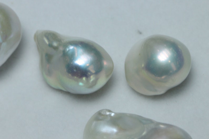 May include: Four iridescent white baroque pearls of varying sizes and shapes.