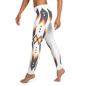 Puede incluir: Leggings blancos con un patrón geométrico negro, rojo y amarillo en los lados.