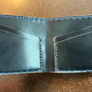 Cartera plegable de cordobán con concha negra y costuras azules