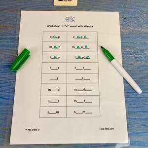 Puede incluir: Una hoja de trabajo con el t&iacute;tulo "Worksheet 1: "a" sound with silent e" y una cuadr&iacute;cula de palabras con letras que faltan. Las palabras son "cap", "cape", "man", "mane", "tap", "tape", "f_t", "f_t", "_t", "_t", "m_d", "m_d", "m_t", "m_t", "sm", "sm".