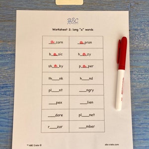 Puede incluir: Una hoja de trabajo con el t&iacute;tulo "Worksheet 2: long "a" words" y una cuadr&iacute;cula de palabras con letras que faltan. Las letras que faltan son todas la letra "a". Hay un marcador rojo en el lado derecho de la p&aacute;gina.
