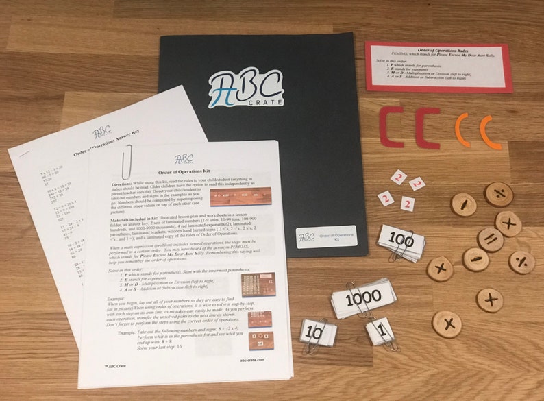 Puede incluir: Un conjunto de materiales educativos para ense&ntilde;ar el orden de las operaciones, que incluye un conjunto de n&uacute;meros de madera, una regla, una gu&iacute;a laminada y un conjunto de hojas de trabajo. Los materiales est&aacute;n etiquetados con el logotipo de ABC Crate.