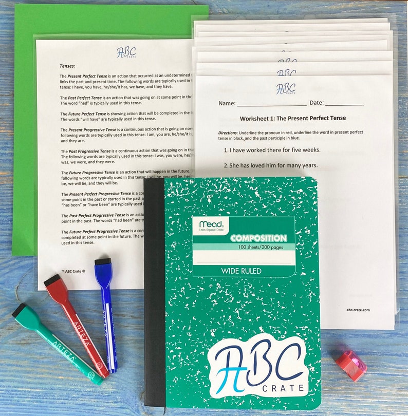 Puede incluir: Un cuaderno de composici&oacute;n verde con una pegatina blanca que dice "ABC Crate" en la parte delantera. El cuaderno es de l&iacute;neas anchas y tiene 100 hojas o 200 p&aacute;ginas. El cuaderno est&aacute; sobre una mesa de madera con tres rotuladores y un l&aacute;piz.