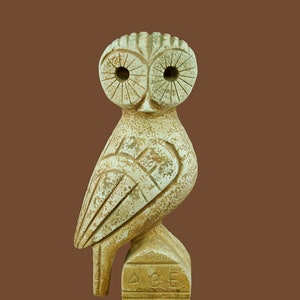 Puede incluir: Una estatua de búho de cerámica blanca con tallado detallado, de pie sobre una base con la inscripción "AGE".