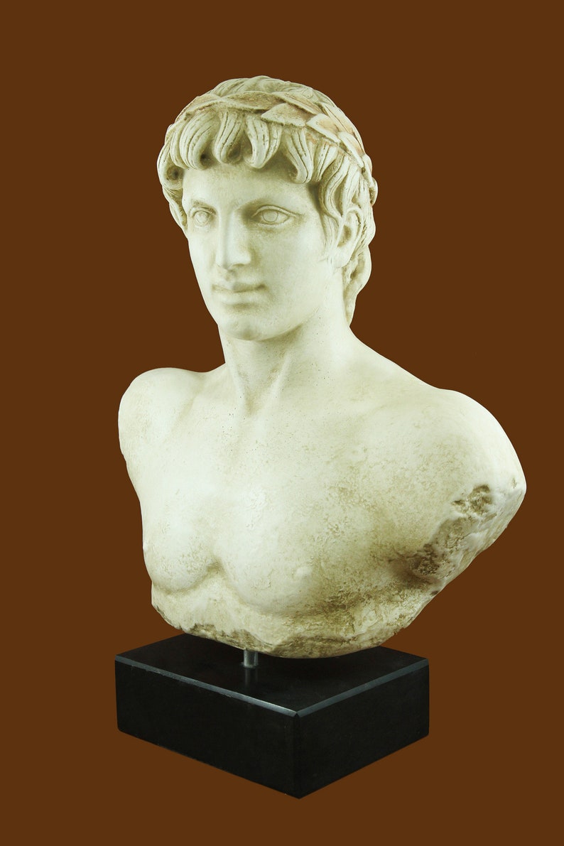 K&ouml;nnte beinhalten: Klassische B&uuml;stenskulptur eines Mannes mit Lorbeerkranz. Die cremefarbene Statue ist auf einem schwarzen rechteckigen Sockel montiert. Die Skulptur hat ein detailliertes Gesicht und eine Brust, vor braunem Hintergrund.