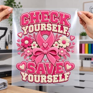 May include: A clear transfer sheet featuring a pink breast cancer awareness ribbon, flowers, and hearts with the text "CHECK YOURSELF, SAVE YOURSELF" in a textured, raised-effect font. The design uses shades of pink and cream throughout.