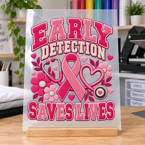 May include: A clear rectangular sheet featuring a pink breast cancer awareness ribbon, a stethoscope, and flowers. The text reads EARLY DETECTION SAVES LIVES in bold pink letters. The design includes small pink hearts and floral accents throughout.
