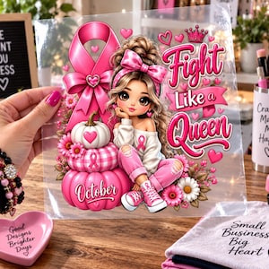 May include: A clear transfer sheet featuring a cartoon girl with brown hair, a pink bow, and pink sneakers sitting next to a stack of pink pumpkins. The design includes a pink awareness ribbon, pink flowers, and the text Fight Like a Queen and October.