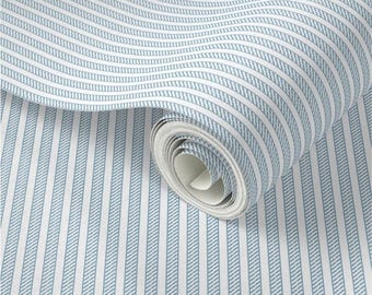 May include: A roll of blue and white striped wallpaper. The wallpaper features vertical stripes of varying widths, with a wavy pattern. The color scheme is a light blue and white, creating a classic and clean aesthetic. The roll is partially unrolled, showing the pattern.