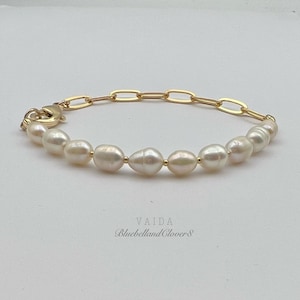 May include: A gold chain bracelet with a clasp and a row of white pearls.