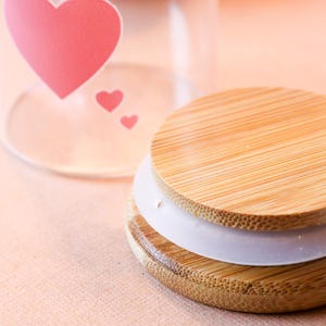 May include: A wooden lid with a white silicone ring, the lid is made of natural bamboo and has a light brown color.