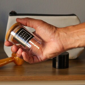 May include: A clear glass jar with a wooden lid and a black label that reads "GOOD VIBES ONLY".