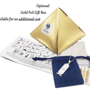 May include: A silver Ankh pendant necklace with a blue velvet pouch and a gold foil gift box. The pendant is a replica of an ancient Egyptian symbol. The box has the text "DISCOVERIES Egyptian Imports" on it. The pouch has a drawstring closure. The image also includes a card with a chart of hieroglyphs.