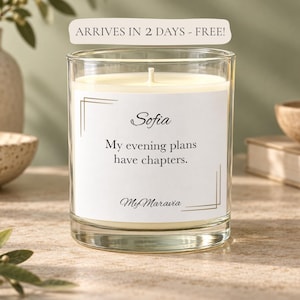 May include: A clear glass candle with white wax and a centered wick. The label features the name Sofia, the text My evening plans have chapters, and the brand name MyMaravia, all framed by thin gold lines on a white rectangular background.