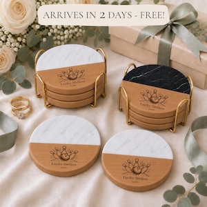 May include: A set of round coasters featuring a split design of natural wood and white or black marble. Each coaster is engraved with a bowling ball and pins graphic and the text Lucky Strikes 2026. The coasters are displayed in gold metal holders.