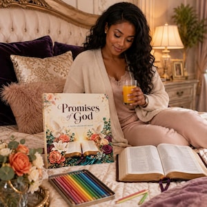 May include: A square coloring book titled Promises of God featuring illustrations of an open Bible, white doves, and colorful flowers. The book is displayed alongside an open Bible, a metal tin of colored pencils, and a glass of orange juice.