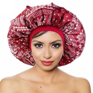 May include: Red satin sleep cap with a white bandana print. The cap is designed to protect hair while sleeping.