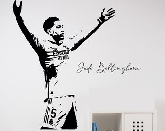 May include: Black and white silhouette wall decal of a soccer player with his arms raised in celebration. The player is wearing a soccer uniform with the number 58 on the back. The decal includes the signature "Jude Bellingham".