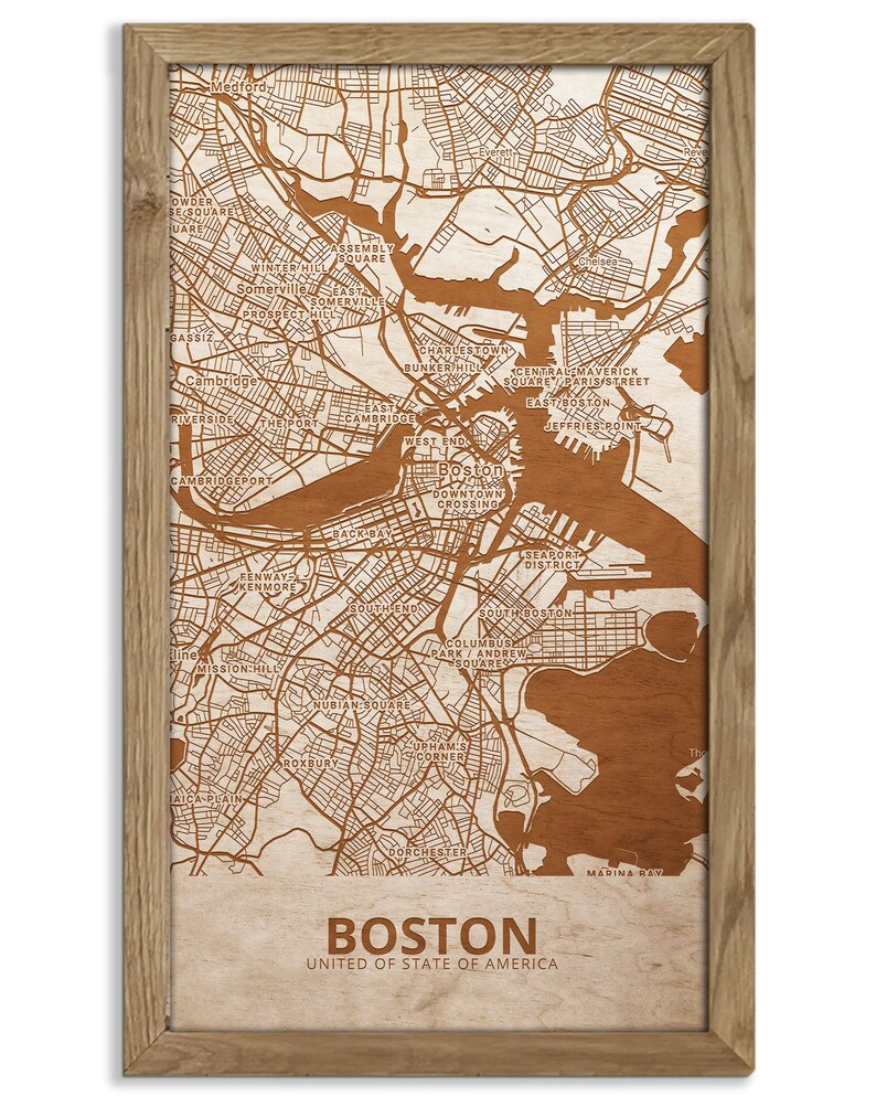May include: A wood-mounted map of Boston, Massachusetts, with the city's streets and neighborhoods outlined in brown. The map is framed in a light brown wood frame. The text "BOSTON" and "UNITED STATES OF AMERICA" is printed below the map.