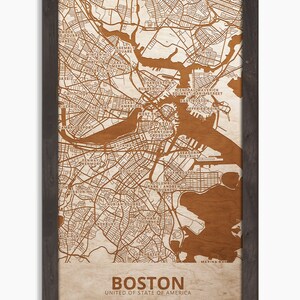 May include: A brown and white map of Boston, Massachusetts, with the city's neighborhoods and major streets labeled. The map is framed in a dark brown wood frame. The text "Boston" and "United States of America" is printed below the map.