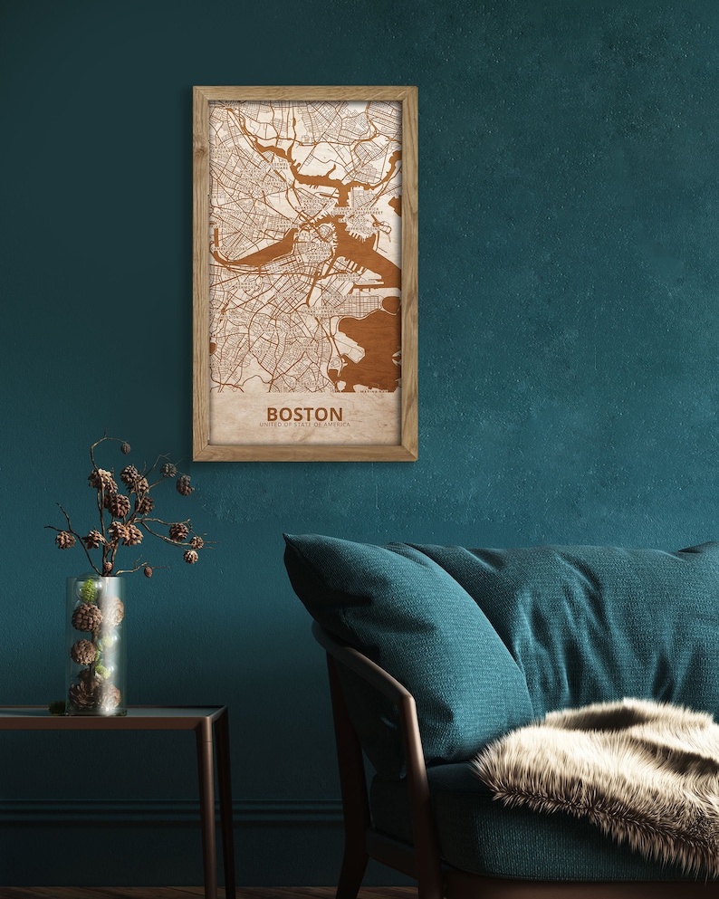 May include: A framed wooden map of Boston, Massachusetts, with a teal green wall and a teal blue couch in the background.