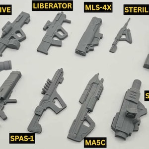 May include: A collection of gray, futuristic-looking toy weapons, including models labeled "CONCUSSIVE," "LIBERATOR," "MLS-4X," "STERILIZER," "RECOILLESS," "QUASAR," "SPAS-1," "MA5C," "SPEAR," and "EAT-17."