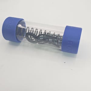 May include: A clear plastic tube containing a metal spring, black rubber rings, and other small metal components. The tube is capped with blue plastic ends, with the word "POT" printed on the side.