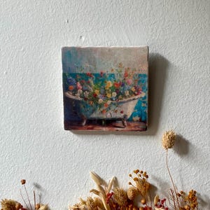 Könnte beinhalten: Eine vintage weiße Badewanne, die überquillt mit bunten Blumen, vor einem blauen und grünen Hintergrund. Die Blumen sind auf eine fantasievolle und künstlerische Weise angeordnet und schaffen eine wunderschöne und lebendige Szene.