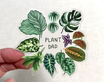 May include: A sticker featuring a variety of green and red tropical plants with the text "PLANT DAD" in the center.