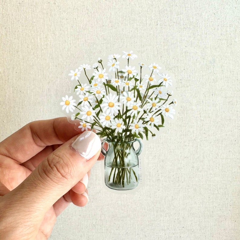 May include: A clear glass vase with a white daisy bouquet. The vase has a rustic, farmhouse style with a textured surface.