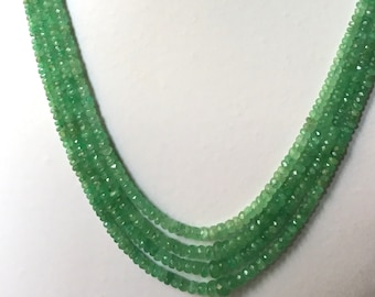 Pode incluir: Um colar de várias voltas feito de contas de pedras preciosas verdes. O colar está em um busto de manequim branco.