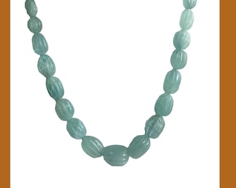May include: A necklace made of light blue aquamarine beads. The beads are oval shaped and have a faceted finish. The necklace is strung on a silver chain.