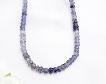 Könnte beinhalten: Eine Kette aus blauen und violetten Edelsteinperlen, aufgereiht auf einem durchsichtigen Faden. Die Perlen sind facettiert und haben eine leicht unregelmäßige Form. Die Kette ist etwa 45 cm lang.