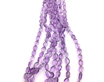 May include: A strand of purple amethyst gemstone beads. The beads are oval shaped and have a smooth, polished finish.