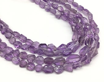 May include: A strand of purple amethyst gemstone beads. The beads are faceted and have a rectangular shape.
