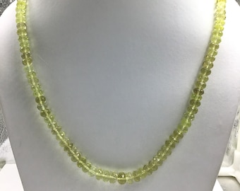 May include: A light green gemstone necklace with round beads. The necklace is on a white background.