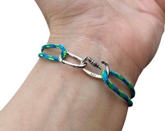 May include: A blue and green rope bracelet with a silver clasp. The clasp is marked with the number "925".