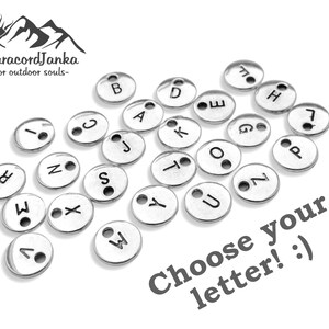 Pu&ograve; includere: Una collezione di ciondoli in metallo argentato a forma di lettere con un foro per la corda. Le lettere sono A, B, C, D, E, G, H, I, J, K, L, M, N, O, P, S, T, U, W, X, Y e Z. Scegli la tua lettera! :)
