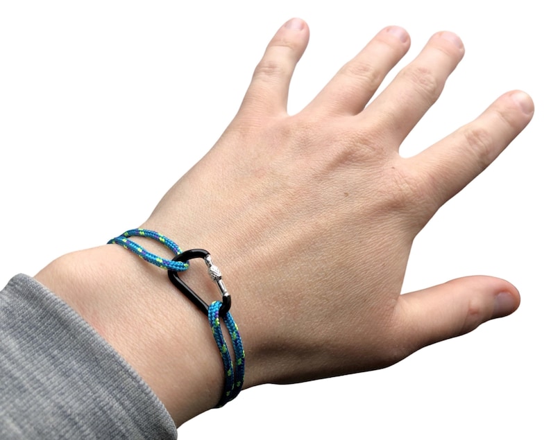 Pu&ograve; includere: Un braccialetto in corda blu e verde con un moschettone nero.