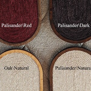 May include: Four oval-shaped cat scratching posts with different wood and rope colors. The posts are made of wood and have a rope covering. The colors are red, dark brown, natural, and natural. The text on the posts reads "Palisander/Red", "Palisander/Dark", "Oak/Natural", and "Palisander/Natural".