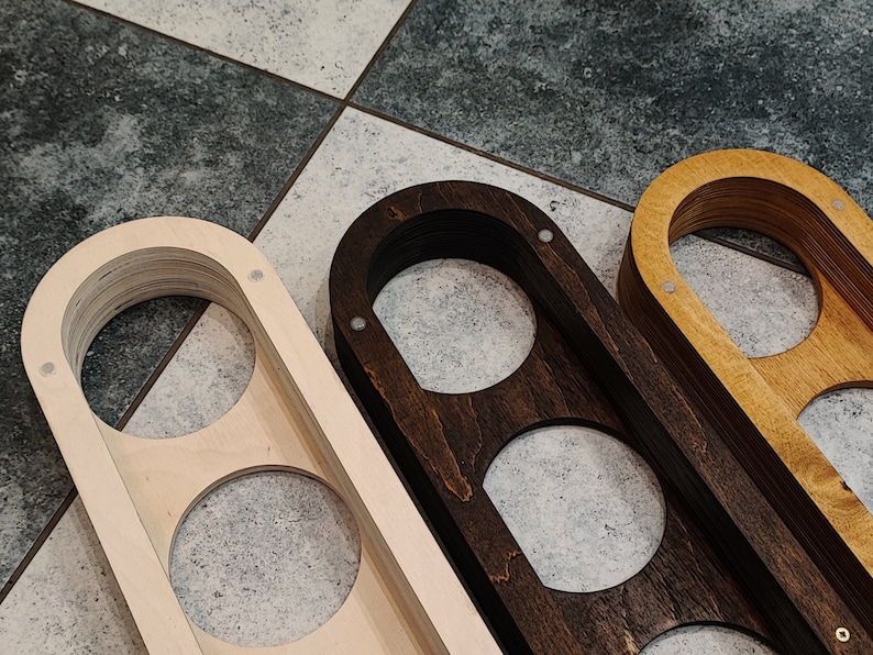 May include: Three wooden wall mounted organizers with three circular cutouts each. The organizers are made of different wood types: natural wood, dark stained wood, and light stained wood.