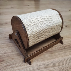 May include: A wooden cat scratching post with a cylindrical sisal rope scratching surface. The post is supported by a wooden frame, providing a durable and engaging surface for cats to scratch and play.