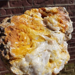 May include: A large, rough, white and yellow crystal cluster with a natural, irregular shape.